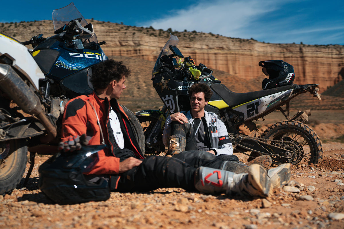Twin Travel guys sitting against their bikes